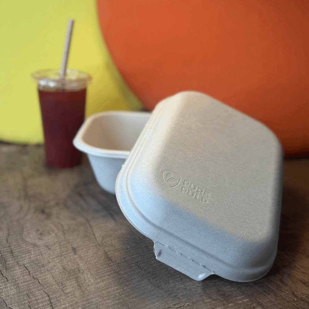 Contenitore a due scomparti per alimenti in polpa avana con coperchio, un'alternativa pratica e sostenibile per catering, asporto e menù con due portate.