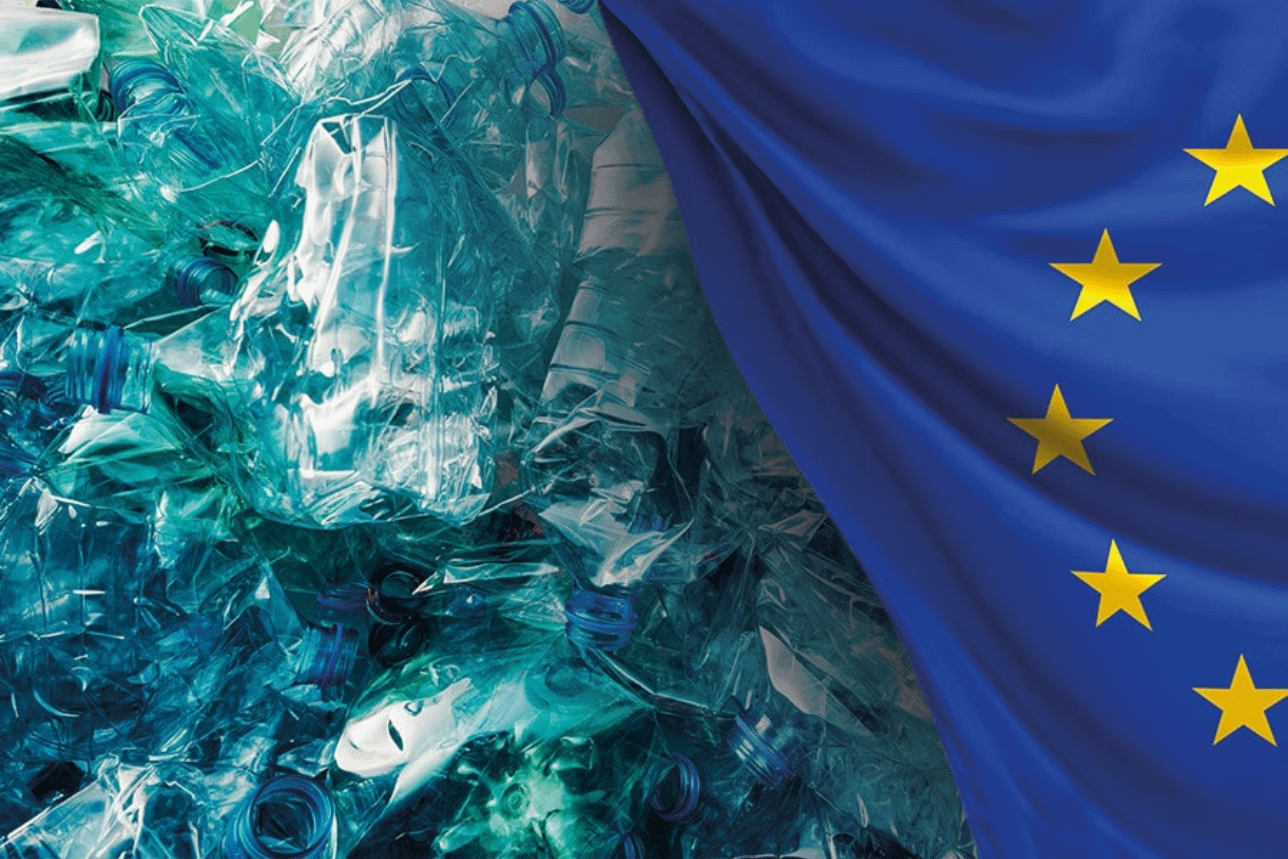 Bottiglie di plastica monouso accanto alla bandiera dell’Unione europea